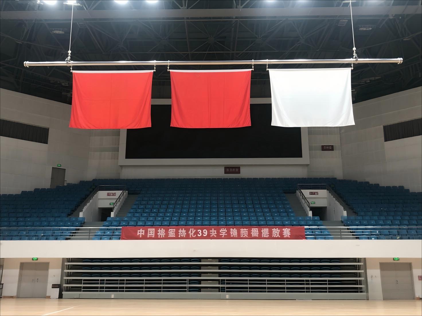 jimeng-2025-08-15-3528-体育馆里正前方悬挂的3面水平旗帜，旗帜悬挂为水平横向，直径63mm的不锈钢.jpg